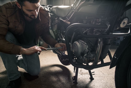 Young man fixing motorcycle in his garage
