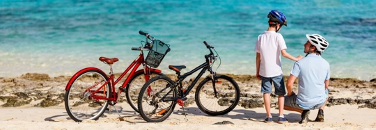Photo of a father and son at the beach with their bikes
